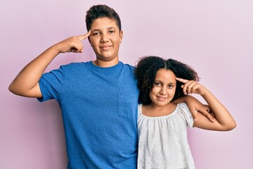 Canvas Print - Young hispanic family of brother and sister wearing casual clothes together smiling pointing to head with one finger, great idea or thought, good memory