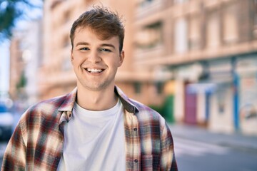 Young caucasian man smiling happy standing at the city.