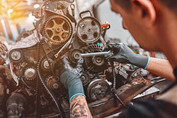 Mechanic repairs the engine of the car in a car-care center.