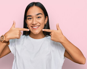 Poster - Young asian woman wearing casual white t shirt smiling cheerful showing and pointing with fingers teeth and mouth. dental health concept.