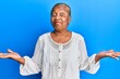 © Krakenimages.com - Senior african american woman wearing casual clothes clueless and confused with open arms, no idea and doubtful face.