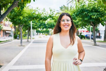 Wall Mural - Young beautiful woman smiling happy. Standing with smile on face looking at the camera walking at town street.