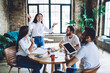 © BullRun - Cheerful young Asian woman presenting ideas to diverse coworkers in office
