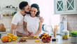 © My Ocean studio - Excited happy beautiful young couple in love cooking in the kitchen and having fun together while making fresh healthy fruits salad