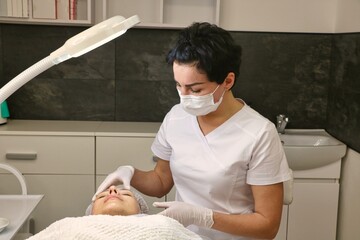 Wall Mural - Preparing the patient s face for a cosmetic procedure, anesthesia cream