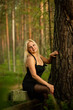 © Ekaterina - blonde girl in black dress in the woods, selective focus
