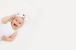 © Any Grant - portrait of a smiling baby girl on a white bed at home, the concept of a happy, healthy baby, a place for text
