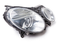 Stylish Xenon Right Headlight Of A German Car - Optical Equipment With A Lamp Inside On A White Isolated Background. Spare Part For Auto Repair In A Car Workshop.