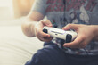 Boy holding a games controller handset and playing online games