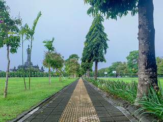 Pedestrian stone ways in city parks. Empty stones road surrounded by trees.