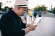 © BullRun - Surprised adult man in straw hat checking mail messages on touch pad and feeling excited, happy shocked male tourist browsing network website with impression news using 4g internet on digital gadget