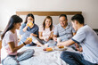 © Marcos - latin Family having breakfast together in bed at home in Latin America