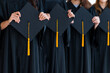 © mnirat - Close up group of graduates holding a hat At the graduation ceremony at the university