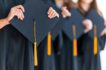 Close up group of graduates holding a hat At the graduation ceremony at the university