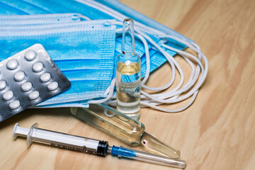 Wall Mural - a syringe tablets in blisters medical hygiene masks and ampoules with medicines on the table