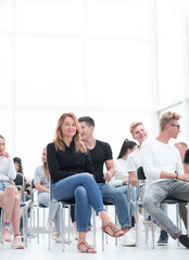 young woman sitting among the listeners of the business seminar