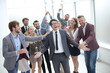 © ASDF - boss and the gleeful business team standing together
