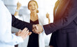 © cameravit - Unknown businesspeople are shaking their hands after signing a contract, while standing together in a sunny modern office, close-up. Business communication concept