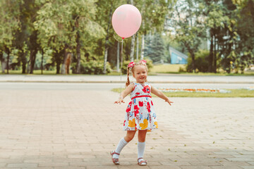 little girl in the park with a balloon