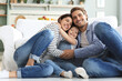 Leinwandbild Motiv Young Caucasian family with small daughter pose relax on floor in living room, smiling little girl kid hug embrace parents, show love and gratitude, rest at home together.
