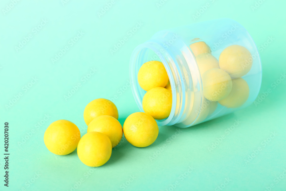 Jar with tasty chewing gums on color background