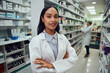 © StratfordProductions - Portrait of young african american pharmacist standing between aisle in chemist