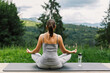 © sonyachny - Young fit woman practising meditation on yoga mat at sunny mountains. Healthy lifestyle outdoor