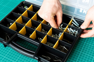 Tool box with cells with screws, anchors, nails, bolts and other tools in workshop