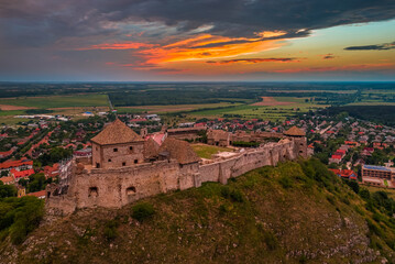 Wall Mural - Sumeg, Hungary - Aerial panoramic view of the famous High Castle of Sumeg in Veszprem county at sunset with storm clouds and dramatic colors of sunset at background on a summer afternoon