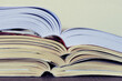 © MEC279 - Closeup of a pile of open books on a table. School, College, University concept. Copy space.