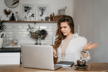 Portrait of angry indignant shocked girl hater, young beautiful nervous stressed woman looking at screen of her laptop computer, shouting, screaming. Online internet aggression, negative emotion.