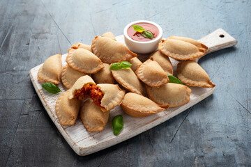 Margarita Margherita pizza parcels pockets filled with tomato, mozzarella cheese and basil served on white wooden board. Party finger food