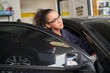 © bank215 - Female technician try to repair car in car service garage