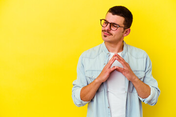 Young caucasian cool man isolated on yellow background making up plan in mind, setting up an idea.