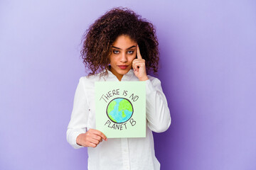 Wall Mural - Young African American woman holding a There is no planet B placard isolated pointing temple with finger, thinking, focused on a task.