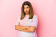© Asier - Young indian woman isolated on pink background frowning face in displeasure, keeps arms folded.