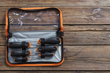 set of screwdrivers in case on dark wooden background