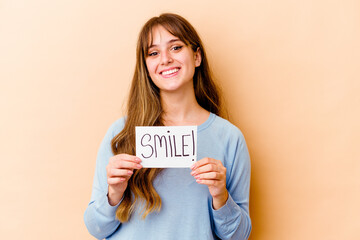 Wall Mural - Young caucasian woman holding a Smile placard isolated happy, smiling and cheerful.