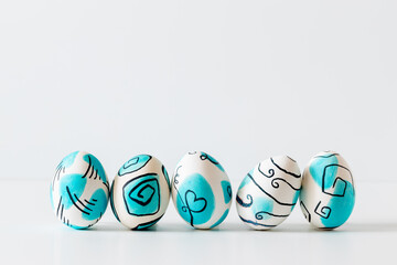 Wall Mural - Creative trendy painted easter eggs on white background.