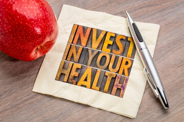 Wall Mural - invest in your health concept - word abstract in vintage letterpress wood type on a napkin with apple, healthy lifestyle advice