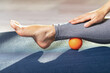 Myofascial relaxation of the leg muscles with a massage ball on a gymnastic mat at home. Prevent leg fatigue