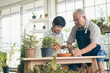 © ronnachaipark - Grandfather gardening and teaching grandson take care  plant indoors