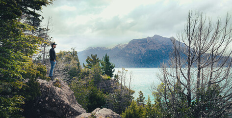 
traveler man looking at nature, forest in front of a lake in patagonia argentina, travel concept