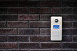 Video intercom on dark brick wall background. Modern, luxury, wealthy home security system. Alarm door bell. Safe entrance to the apartment. Smart home technology, street view. Close up, copy space