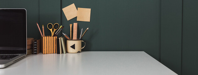 Home office desk with dark green wall and white table mock up.	