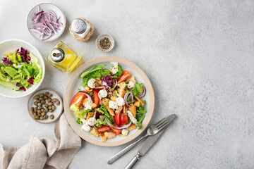 Wall Mural - Panzanella salad with mozzarella cheese and capers on a plate, top view. Healthy italian vegetable tomato salad. Copy space for text or design or recipe