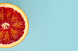 One slice of red oranges on a trendy blue background. Top view and copy space