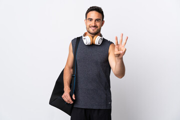 Young sport man with sport bag isolated on white background happy and counting three with fingers