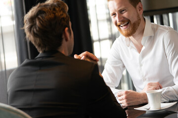 Sticker - Image of young businessman with cup of coffee communicating with colleague