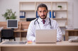 © Elnur - Young male doctor sitting in the office
